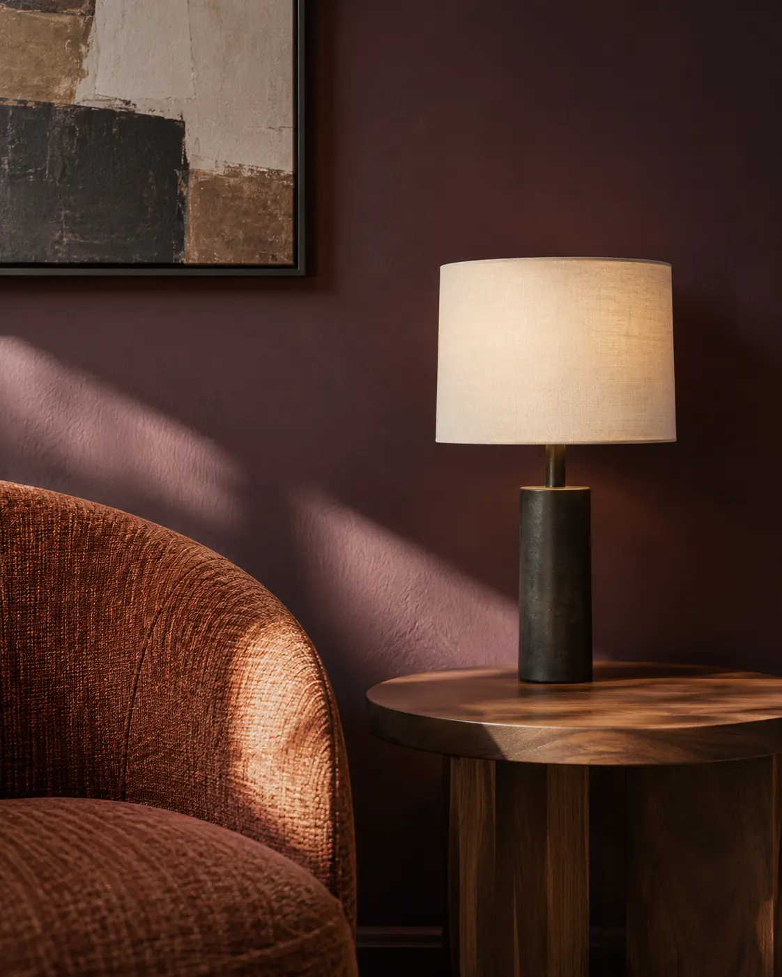 Walnut side table, shaded lamp and rust-coloured chair against an aubergine wall